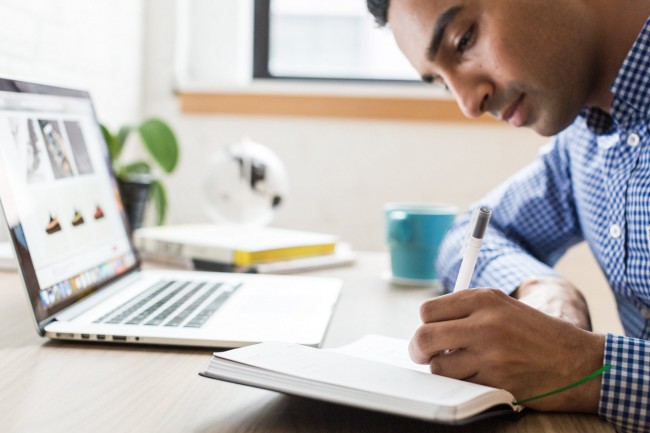 man writing laptop